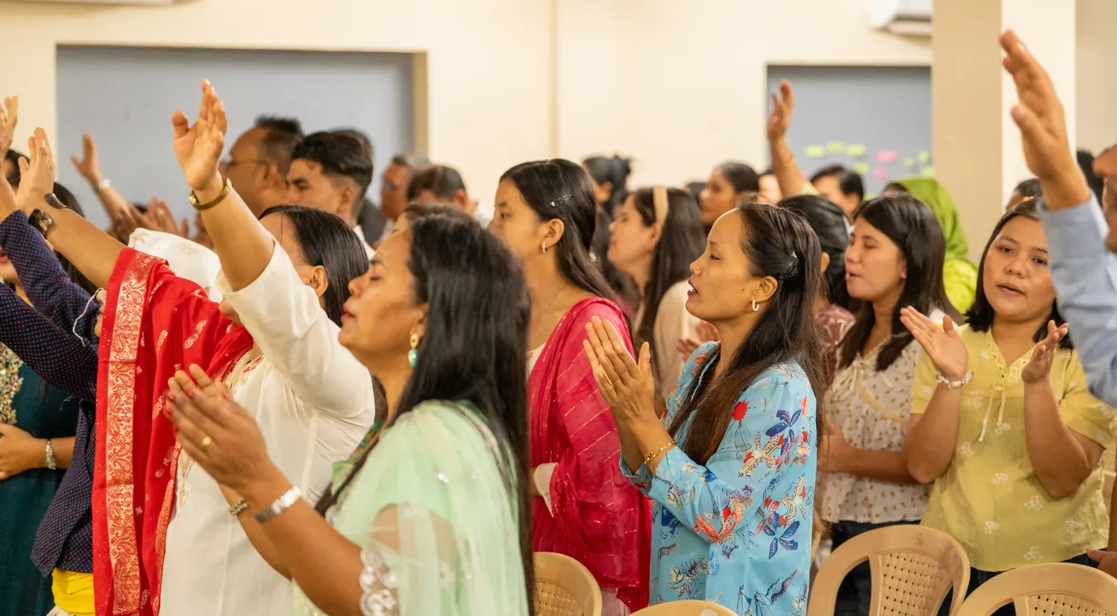 Worshippers with raised hands during a service at Great Hope Nepali Church in Bangalore.